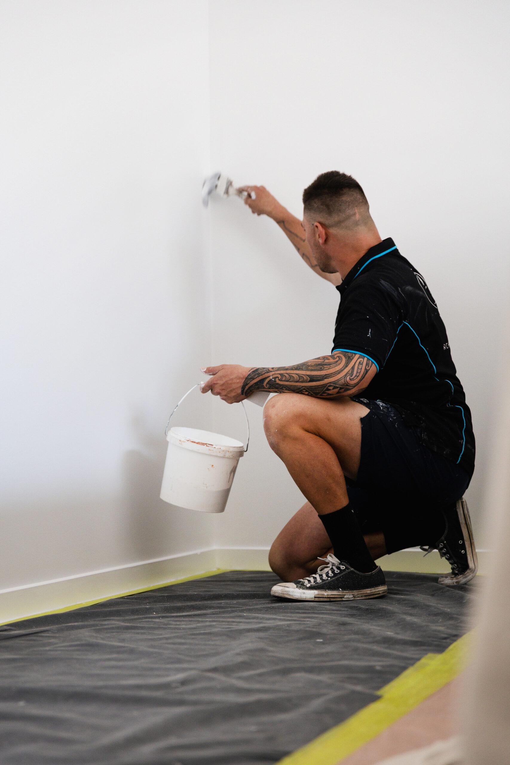 Professional painter applying paint to an interior wall during a Sunshine Coast house painting project